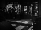 Saboteur (1942) - film frame - Film frame from ''Saboteur'' showing Hitchcock's cameo as the man talking to a woman outside the drugs store.